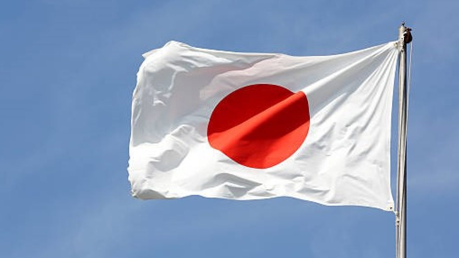 Japanese flag in wind against a blue sky